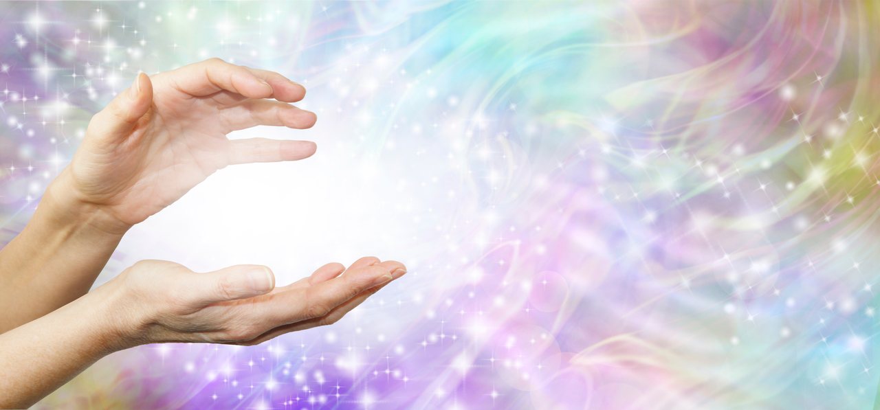 A pair of hands with a soft white orb of light between them